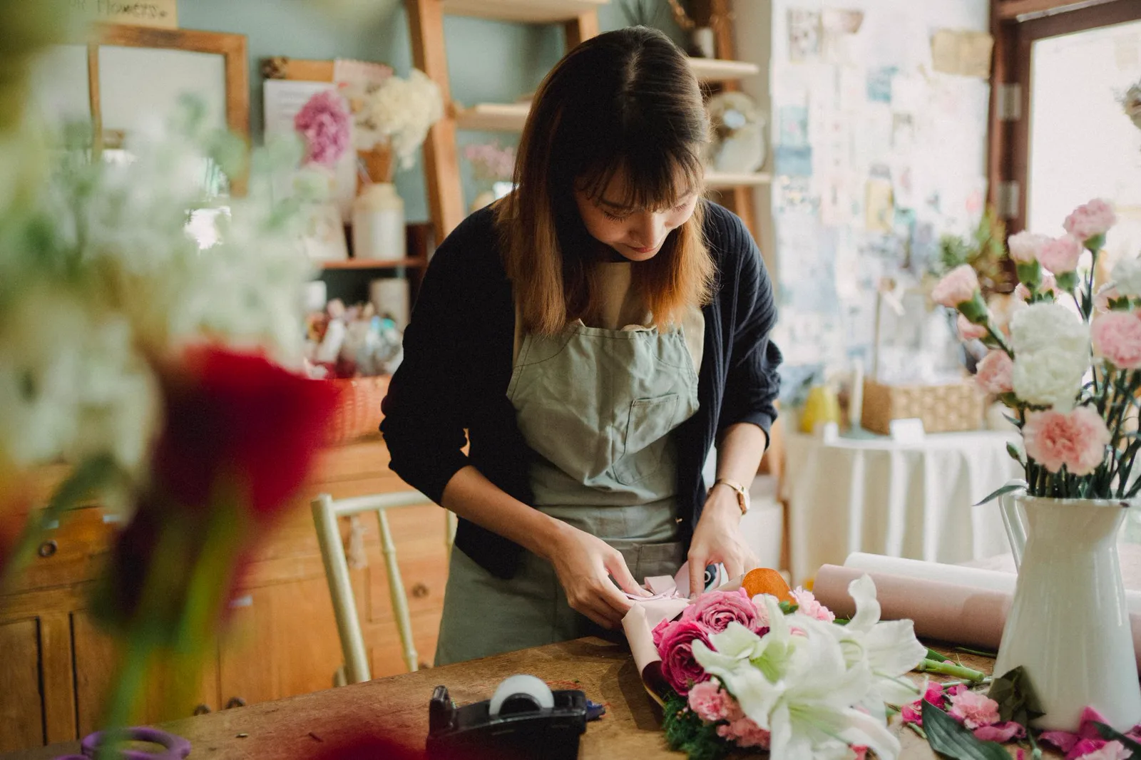 A florist carefully arranging fresh flowers in her studio